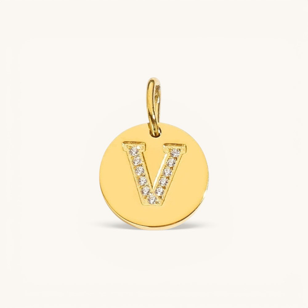 Nadare Co. gold initial V charm with pavé set cubic zirconia on a polished disc.