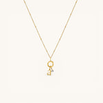 Nadare Co. gold chain necklace featuring a delicate letter charm and a sparkling mini birthstone pendant.