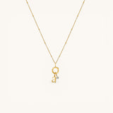 Nadare Co. gold chain necklace featuring a delicate letter charm and a sparkling mini birthstone pendant.