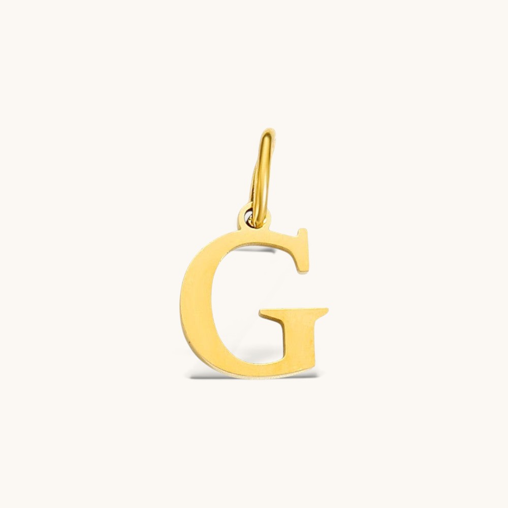 Nadare Co. gold-plated stainless steel initial charm featuring a polished serif letter G on a light background.