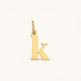 Nadare Co. lowercase letter k charm in 14k gold-plated stainless steel with a polished finish.