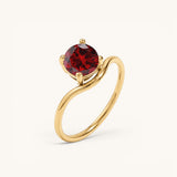 Nadare Co. Lumen birthstone ring featuring a round red garnet stone set in a polished gold band.
