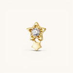 Nadare Co. gold titanium shooting star threadless piercing front with a central cubic zirconia and dangling charm.