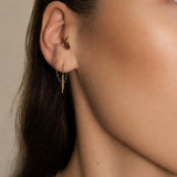 Nadare Co. gold chain threader earrings worn in a pierced earlobe with a small hoop in the tragus