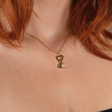 Nadare Co. 14k gold plated gothic initial and birthstone necklace worn on a person with red hair.