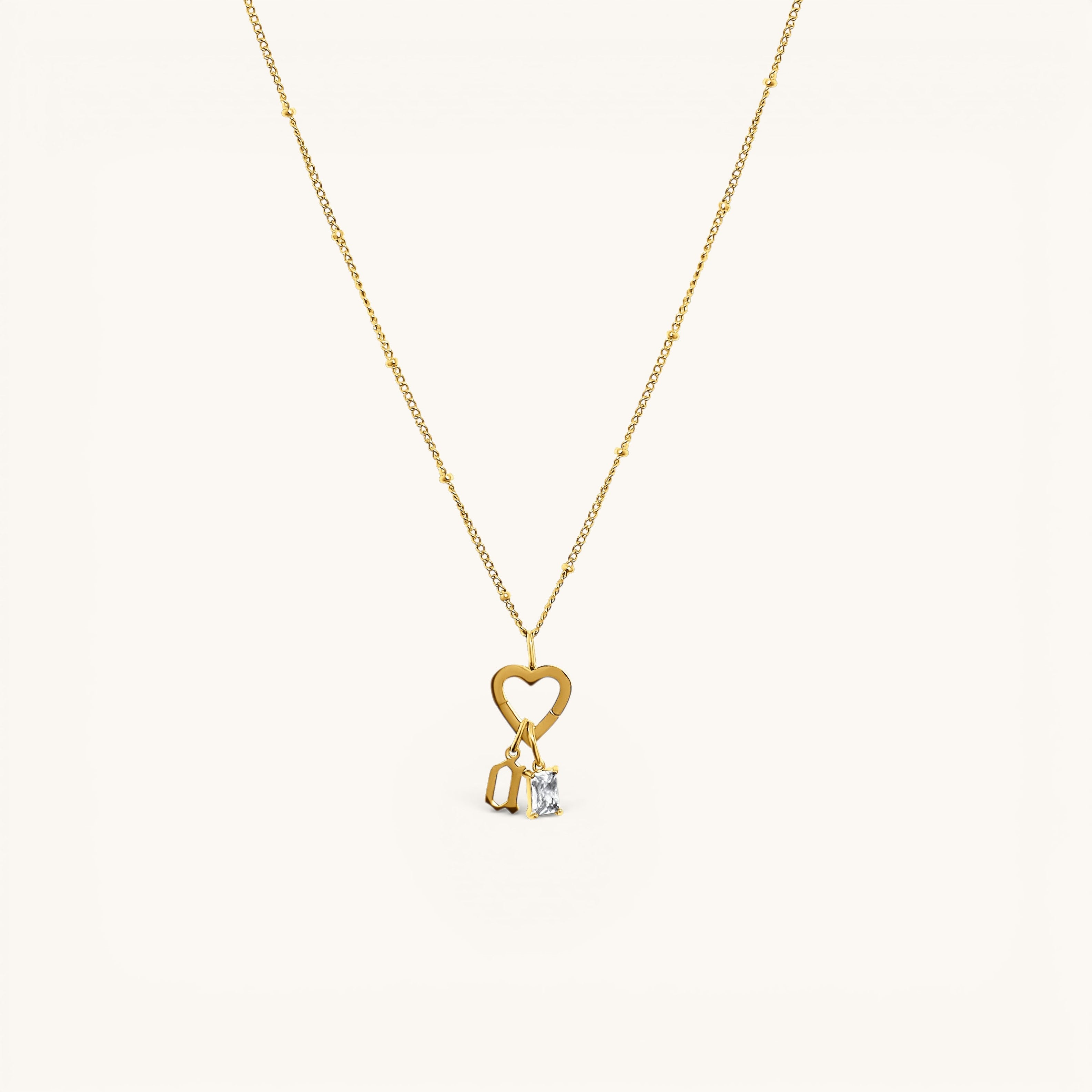 Nadare Co. 14k gold plated necklace featuring a gothic initial charm and a sparkling rectangular birthstone pendant.