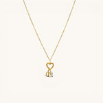 Nadare Co. gold necklace featuring a heart charm, a gothic initial pendant, and a sparkling rectangular birthstone.
