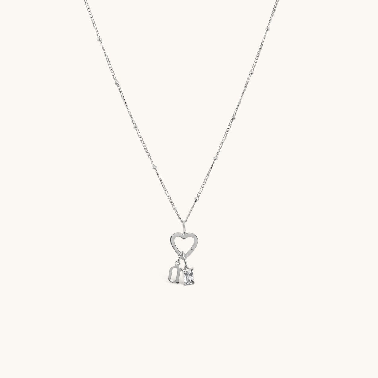 Nadare Co. silver gothic initial and birthstone necklace featuring a heart charm on a delicate beaded chain