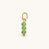 Nadare Co. birth month bead charm featuring three faceted green crystals on a gold jump ring for necklace stacking.