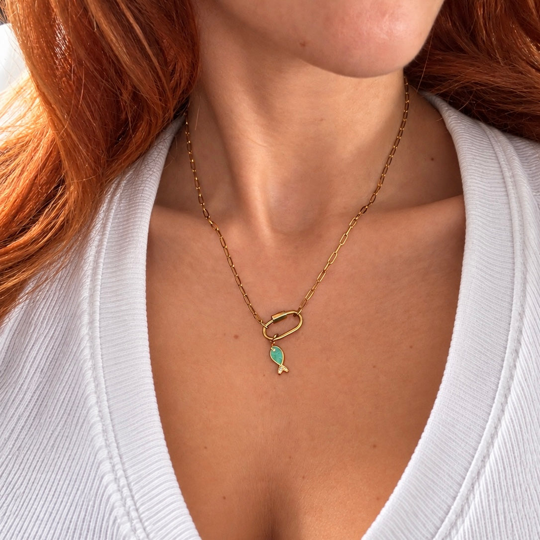 Nadare Co. gold chain necklace featuring a small green enamel fish charm with a cubic zirconia tail on a model