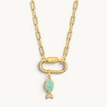 Nadare Co. gold chain necklace with a green enamel fish charm featuring cubic zirconia accents on a carabiner clasp.
