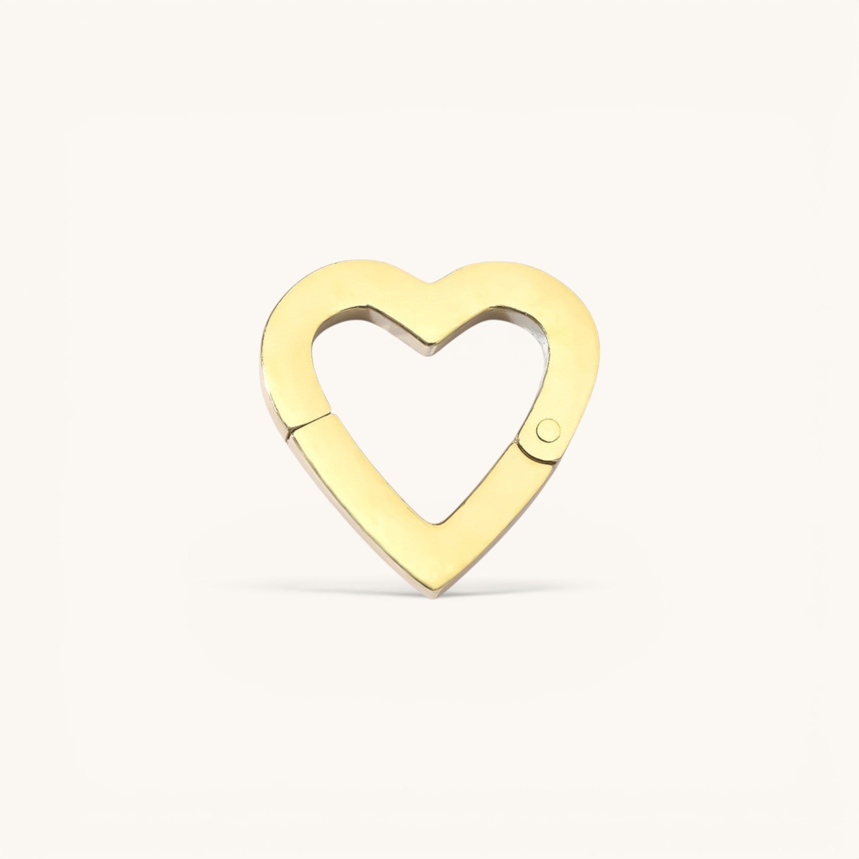 Nadare Co. gold heart-shaped switch clasp for charm necklaces with a polished finish on a neutral background.