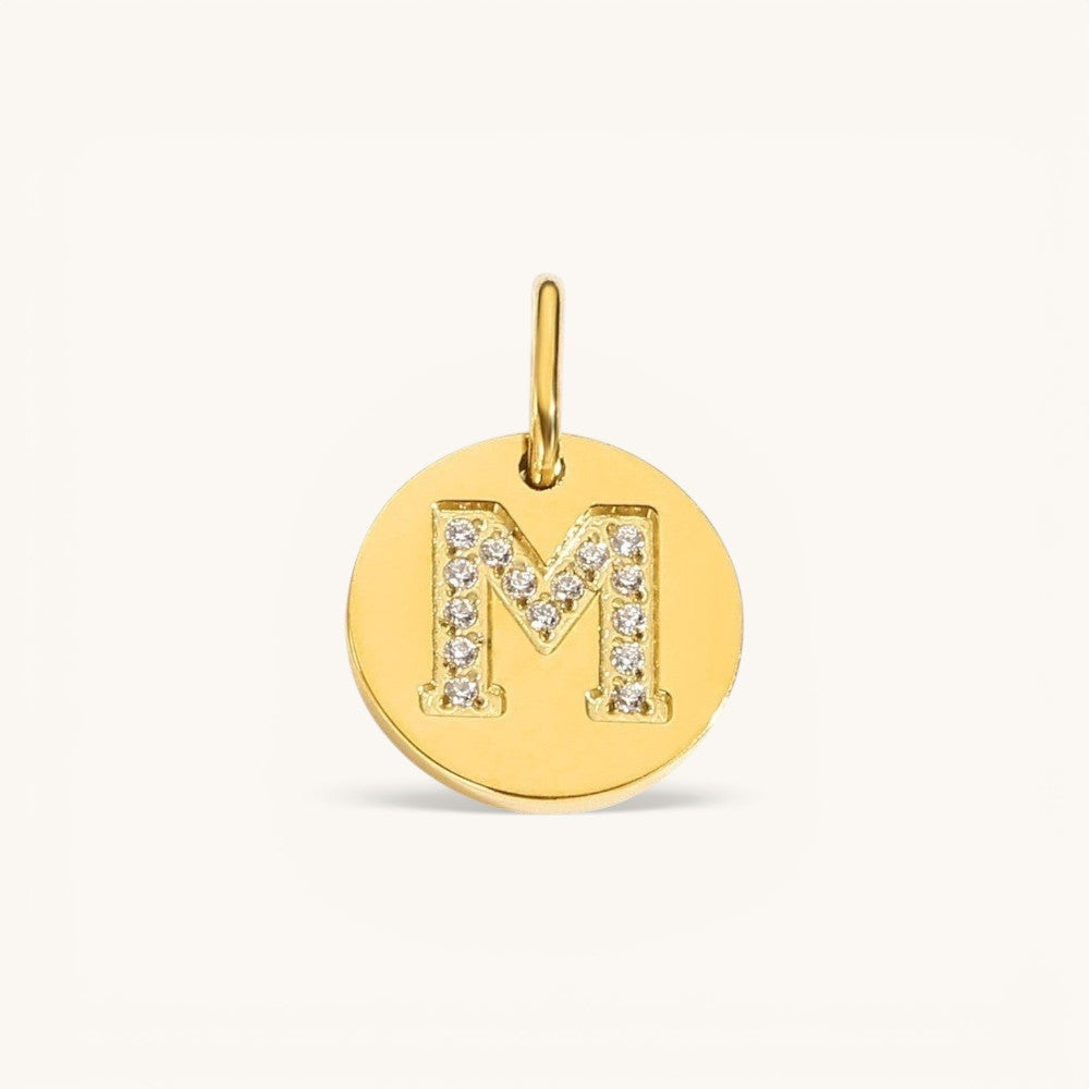 Nadare Co. gold initial M charm with pavé diamond detailing on a polished disc.