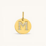 Nadare Co. gold initial M charm with pavé diamond detailing on a polished disc.