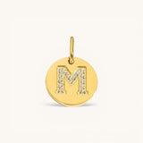 Nadare Co. gold initial M charm with pavé diamond detailing on a polished disc.