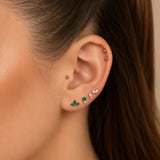 Nadare Co. Ivy threadless earring featuring three marquise-cut emerald green stones in a gold fan design on an ear.