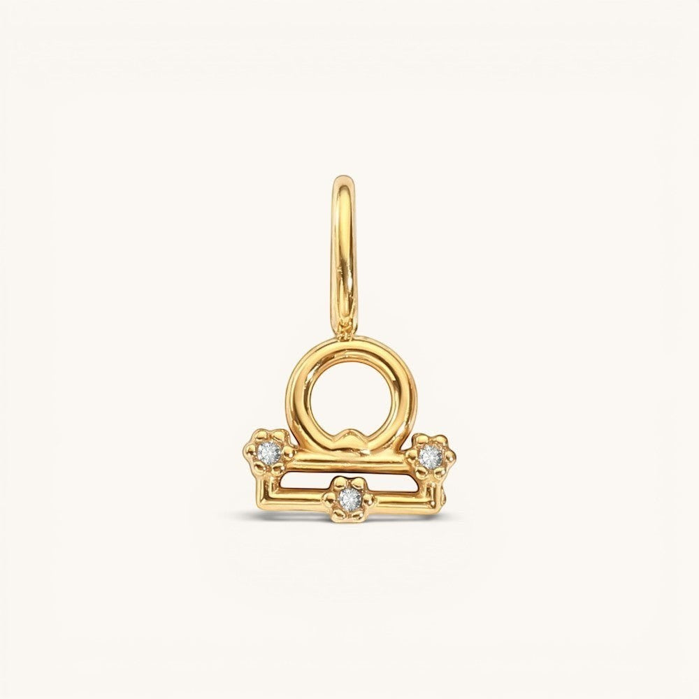 Nadare Co. gold-plated Libra zodiac charm featuring cubic zirconia accents on a stainless steel base.