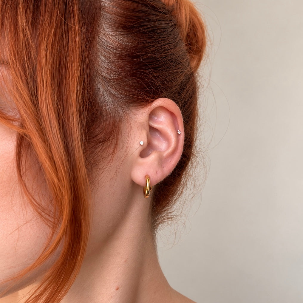 Nadare Co. Lola Hoops in polished gold stainless steel worn on a woman's earlobe for an everyday look