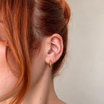 Nadare Co. Lola Hoops in polished gold stainless steel worn on a woman's earlobe for an everyday look