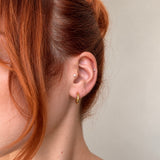 Nadare Co. Lola Hoops in polished gold stainless steel worn on a woman's earlobe for an everyday look