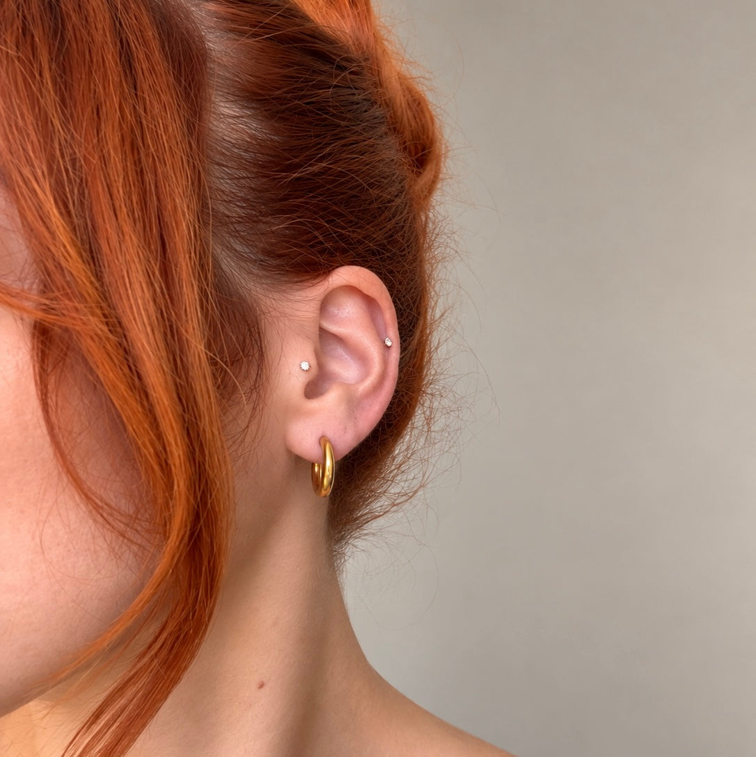 Nadare Co. Lola Hoops in polished gold stainless steel worn on a model with red hair