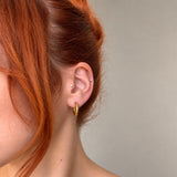 Nadare Co. Lola Hoops in polished gold stainless steel worn on a model with red hair