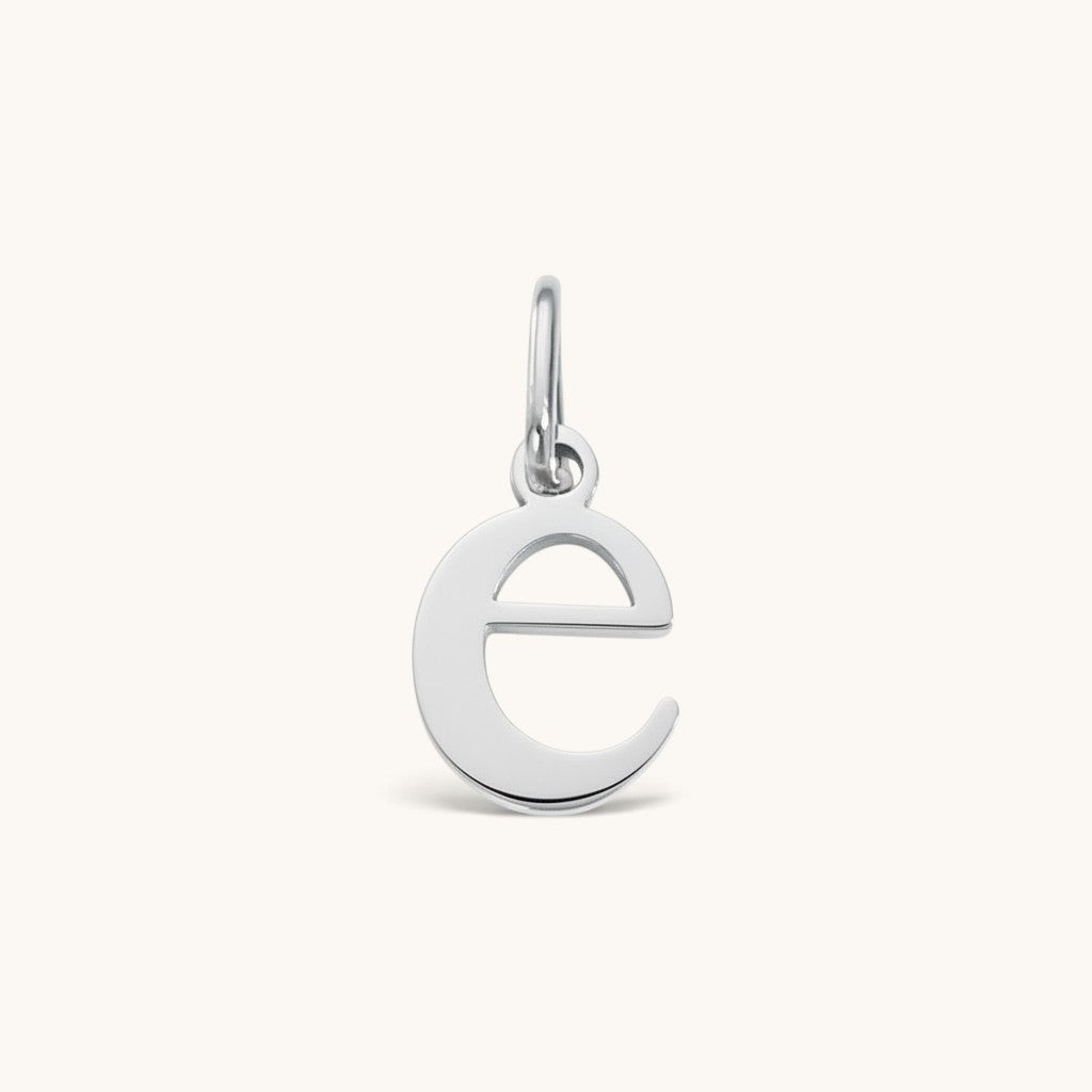 Nadare Co. lowercase letter e charm in polished silver-tone stainless steel for everyday layering.