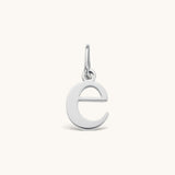 Nadare Co. lowercase letter e charm in polished silver-tone stainless steel for everyday layering.