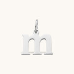 Nadare Co. lowercase letter m charm in polished silver-tone stainless steel for everyday layering.