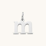 Nadare Co. lowercase letter m charm in polished silver-tone stainless steel for everyday layering.