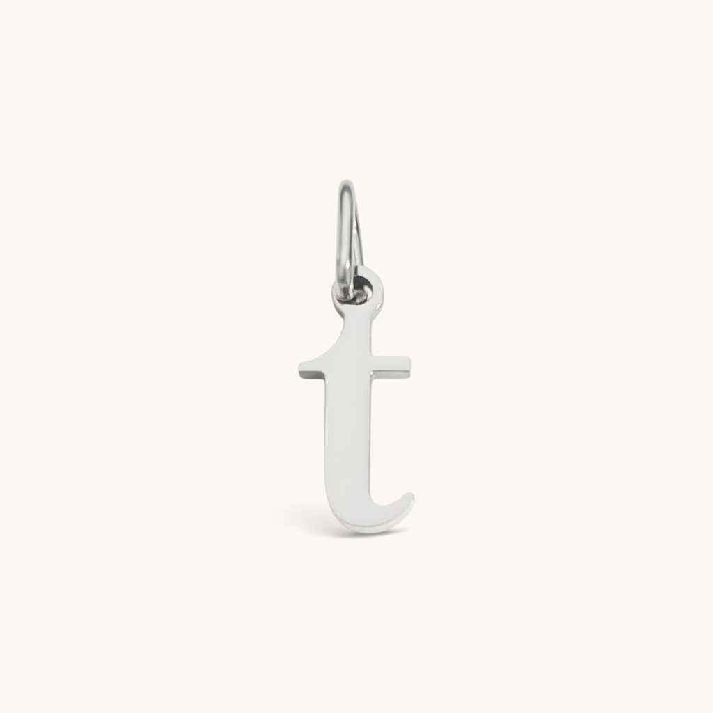 Nadare Co. lowercase letter t charm in silver-toned stainless steel for everyday layering and jewelry styling.