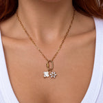 Nadare Co. gold chain necklace featuring a marquise flower charm with cubic zirconia and a white floral pendant.