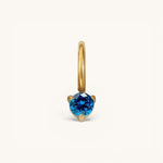 Nadare Co. mini birthstone charm featuring a round-cut blue gemstone set in polished gold on a small hoop.
