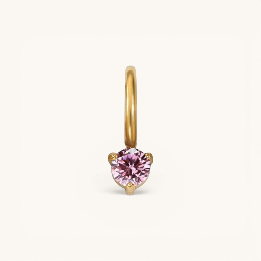 Nadare Co. mini birthstone charm featuring a round pink gemstone set in polished gold on a small hoop.