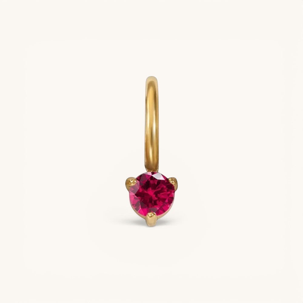 Nadare Co. mini birthstone charm featuring a round-cut vibrant red gemstone set in polished gold.