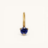 Nadare Co. mini gold hoop charm featuring a round-cut blue sapphire birthstone in a three-prong setting.
