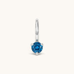 Nadare Co. mini birthstone charm featuring a round blue cubic zirconia stone set in silver-tone stainless steel.