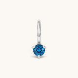Nadare Co. mini birthstone charm featuring a round blue cubic zirconia stone set in silver-tone stainless steel.