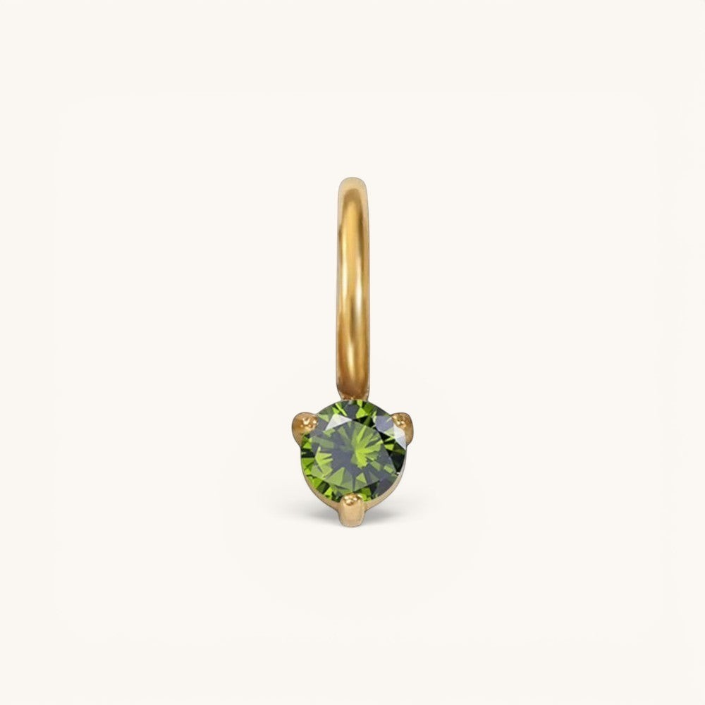 Nadare Co. mini gold birthstone charm featuring a round-cut green gemstone in a delicate prong setting.