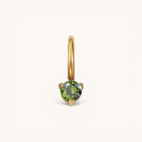 Nadare Co. mini gold birthstone charm featuring a round-cut green gemstone in a delicate prong setting.