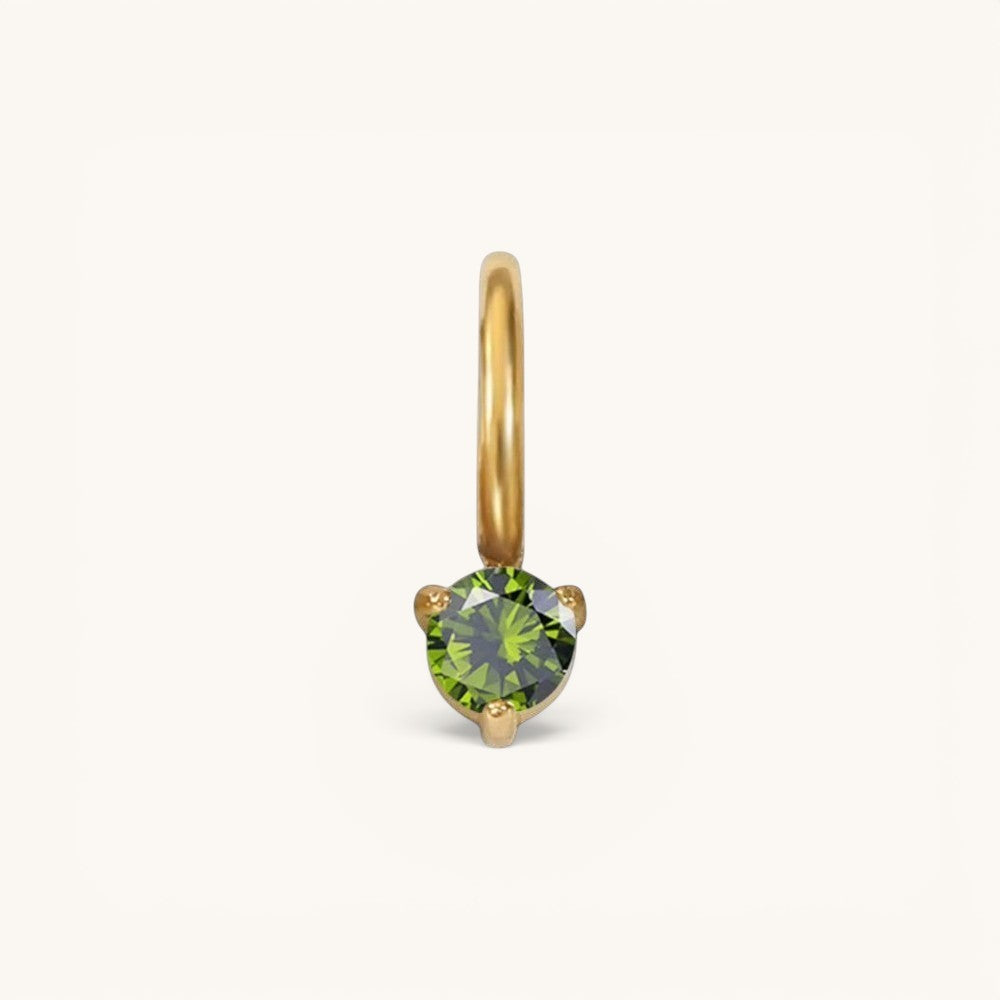 Nadare Co. mini gold birthstone charm featuring a round-cut green gemstone in a delicate prong setting.