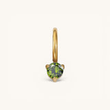 Nadare Co. mini gold birthstone charm featuring a round-cut green gemstone in a delicate prong setting.