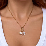 Nadare Co. gold chain necklace featuring a mother of pearl clover charm and a sparkling flower pendant