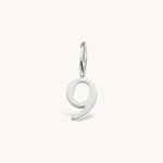 Nadare Co. number 9 charm in silver-toned stainless steel for minimalist jewelry layering.
