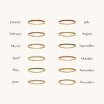 Nadare Co. Prism Birthstone Rings featuring twelve thin gold bands with colorful gemstones for each month of the year.