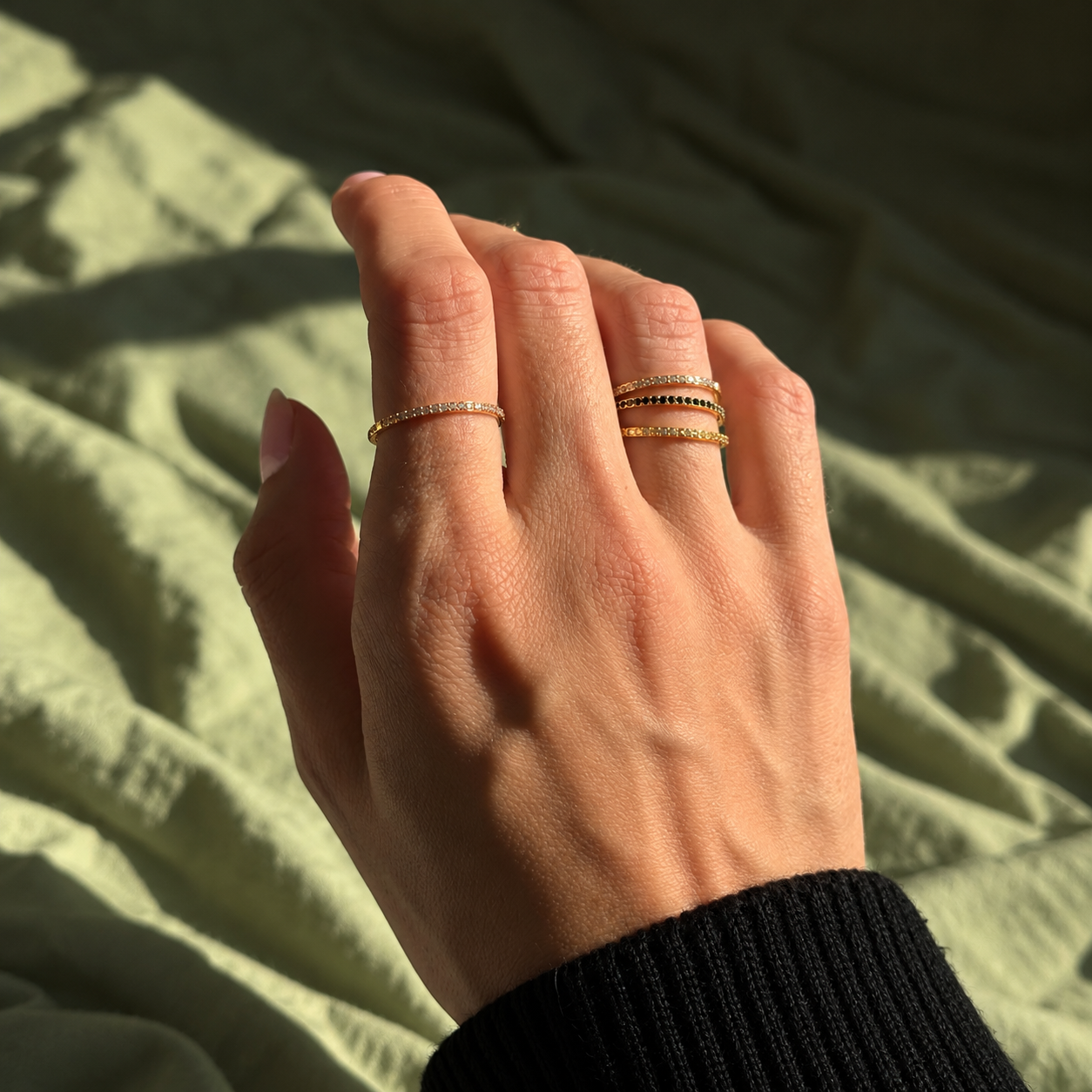 Nadare Co. Prism Birthstone Ring stacked on a hand with delicate gold bands and sparkling gemstone accents