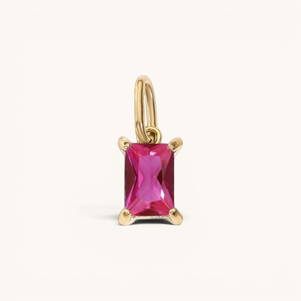 Nadare Co. rectangle birthstone charm featuring a vibrant pink gemstone set in polished gold on a simple bail.