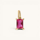 Nadare Co. rectangle birthstone charm featuring a vibrant pink gemstone set in polished gold on a simple bail.