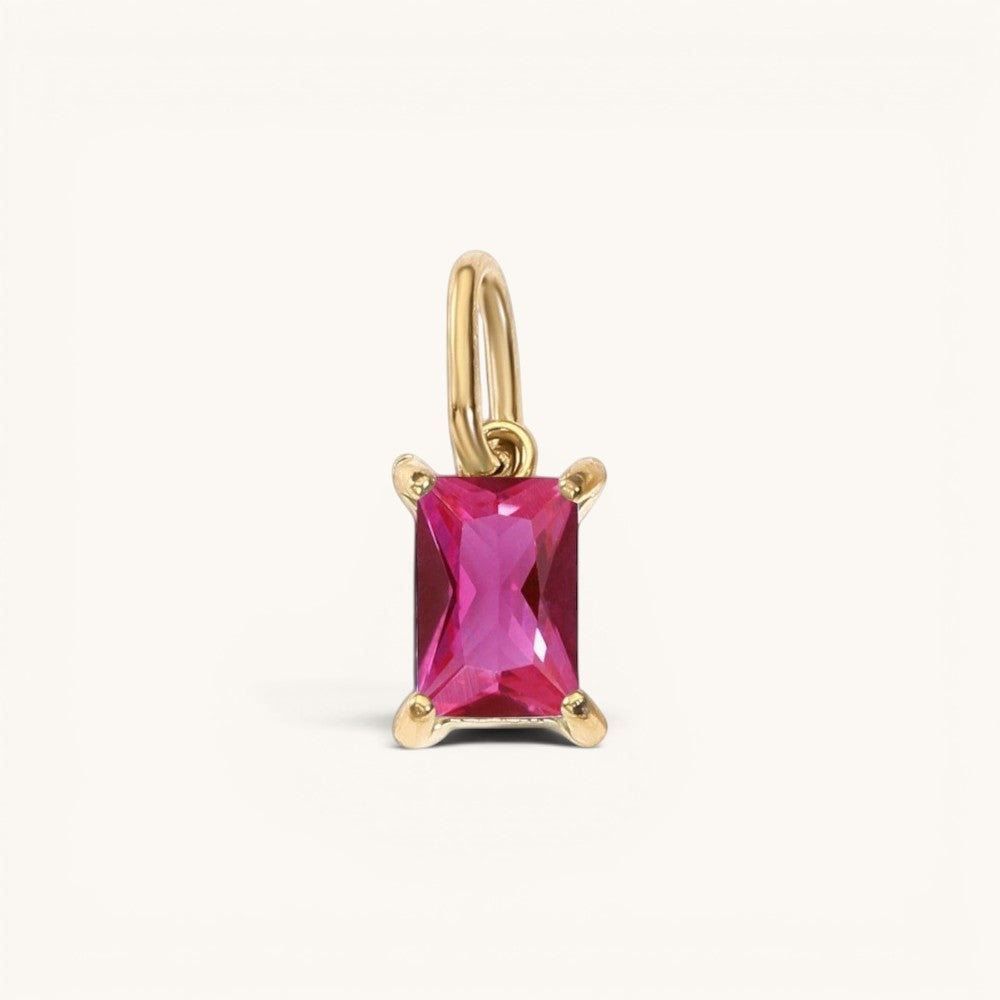 Nadare Co. rectangle birthstone charm featuring a vibrant pink gemstone set in polished gold on a simple bail.