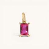 Nadare Co. rectangle birthstone charm featuring a vibrant pink gemstone set in polished gold on a simple bail.